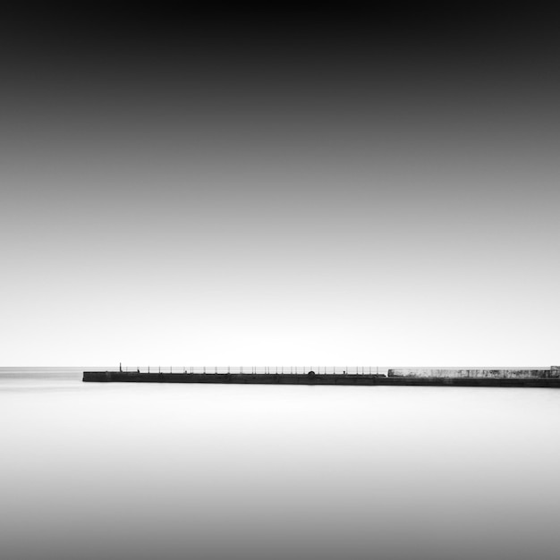 Photo pier au milieu de la mer contre le ciel par temps brumeux