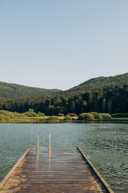 Pier en bois lac entouré de montagnes Slovénie Le concept des vacances d'été vacances