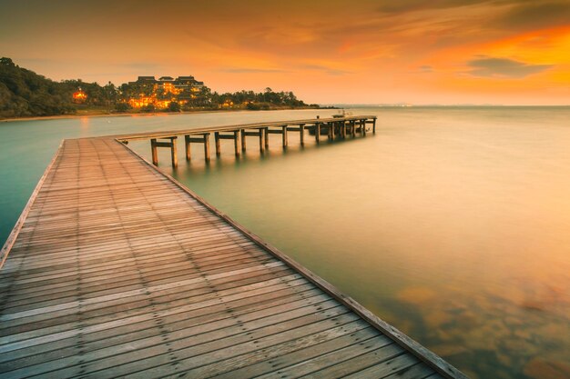 Photo pier sur la mer contre le ciel orange