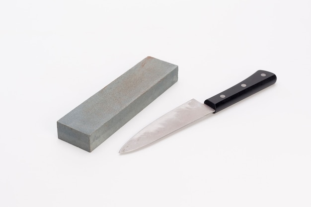 Photo pierre à aiguiser et couteau sur fond blanc