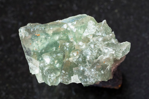 Pierre gemme cristalline verte de fluorite sur l'obscurité