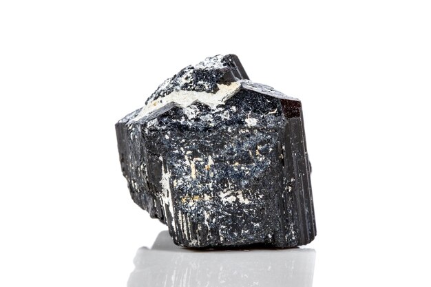 Pierre minérale macro sherle schorl tourmaline noire sur fond blanc