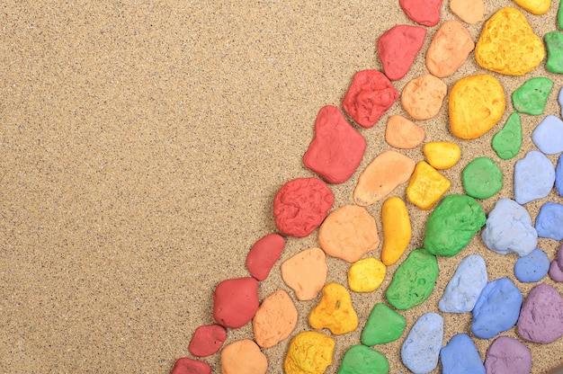 Pierres colorées disposées sur le sable avec espace de copie