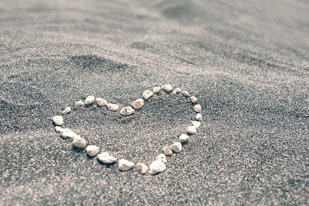 Pierres en forme de coeur sur la plage de sable noir. Faible profondeur de champ