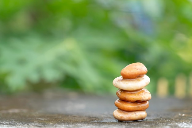 Pierres de méditation avec de l'eau de goutte de pluie sur le sol en ciment sur fond de nature verdoyante Espace libre de cailloux pyramidaux Symbole de bouddhisme calme ou concept d'ensemble d'aromathérapie