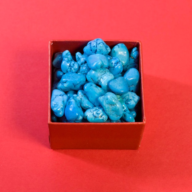 Pierres précieuses de bijou turquoise sur fond rouge vif groupe d'objets