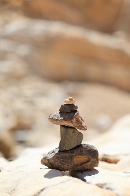 Les pierres pyramidales s'équilibrent sur le sable du désert l'objet est au point l'arrière-plan est flou salut