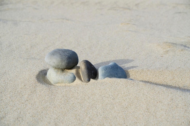 Les pierres sont recouvertes de sable de quartz sur la plage par vent fort