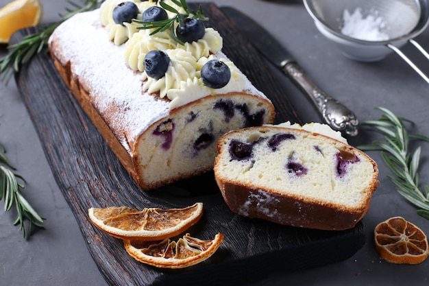 Piese gâteau maison avec crème de biscuit décorée de citron et de myrtille.