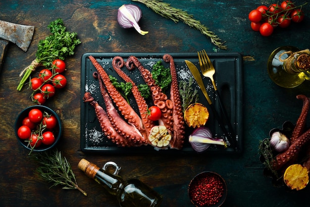 Pieuvre cuite au four avec de l'ail citronné et du persil sur une planche de bois noire Vue de dessus Mise à plat