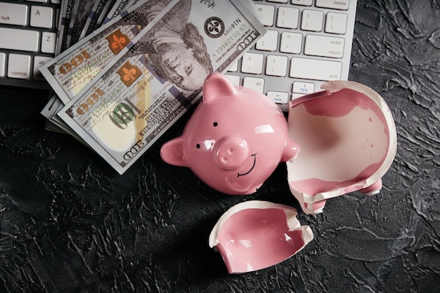 Piggy cassé et argent sur le clavier Cyber crime fraude en ligne Faillite ou perte d'épargne