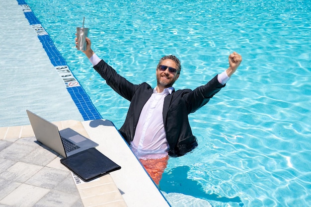 Pigiste d'affaires indépendant d'été sur la plage de mer d'été pigiste fou en costume dans l'eau de mer folle