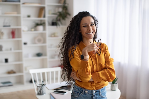 Pigiste arabe gai debout souriant à la caméra à la maison