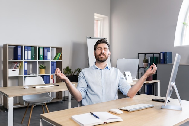 Un pigiste au bureau médite et effectue des exercices de respiration, l'homme d'affaires se calme