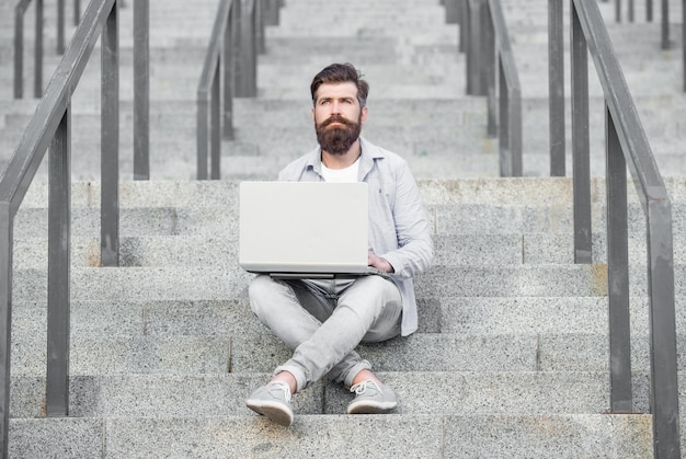 Un pigiste barbu a une communication en ligne sur un ordinateur portable