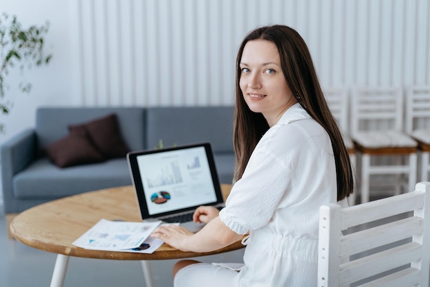 Pigiste féminin assis à un bureau dans son bureau à domicile