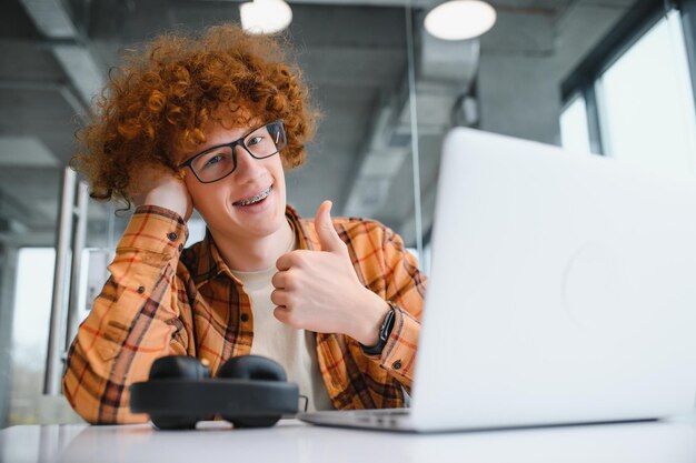 Un pigiste masculin élégant travaillant sur un nouveau projet de démarrage permettant aux chercheurs d'Internet d'analyser des données à l'aide d'un ordinateur portable