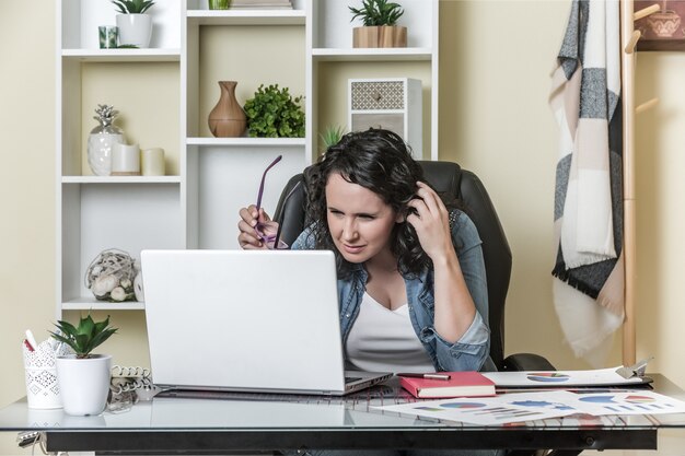 Pigiste pensif utilisant un ordinateur portable à la maison