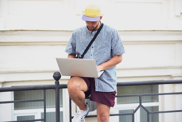 Un pigiste travaillant à l'aide de l'ordinateur portable dans la rue