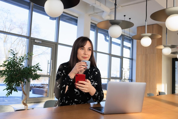 Un pigiste travaille dans un café une jeune femme envoie des SMS au téléphone