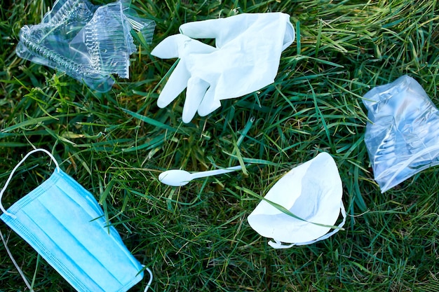 Piile d'ordures éparpillées sur fond d'herbe verte