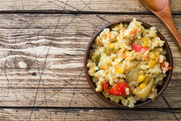 Pilaf aux légumes et au poulet dans un bol en bois Espace copie