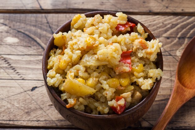 Pilaf aux légumes et au poulet dans un bol en bois