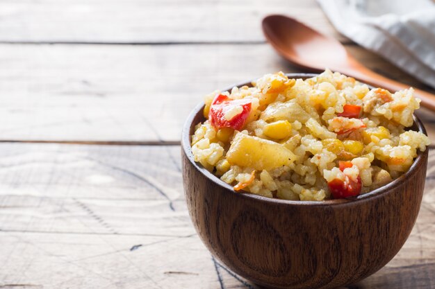 Pilaf aux légumes et au poulet dans un bol en bois