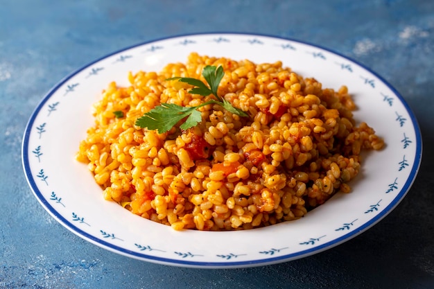 Photo pilaf de boulgour turc traditionnel avec sauce tomate dans une assiette (nom turc ; meyhane pilavi)