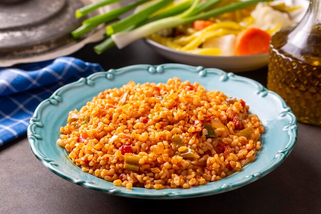 Pilaf de boulgour turc traditionnel avec sauce tomate dans une assiette nom turc meyhane pilavi