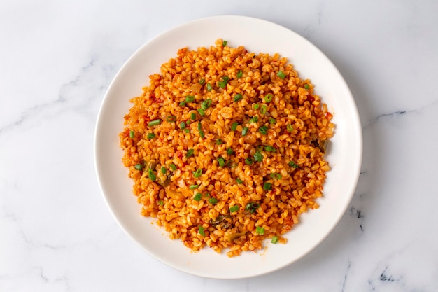 Pilaf bulgur turc traditionnel avec sauce tomate dans une assiette nom turc meyhane pilavi