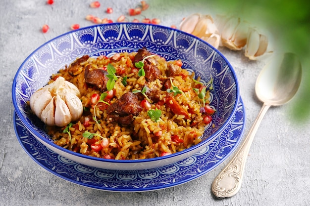 Pilaf et ingrédients sur plaque agrandi. Pilaf national ouzbek avec de la viande.