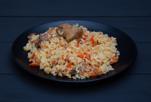 Pilaf traditionnel savoureux à l'ail et aux épices sur plaque noire. Plat national ouzbek.