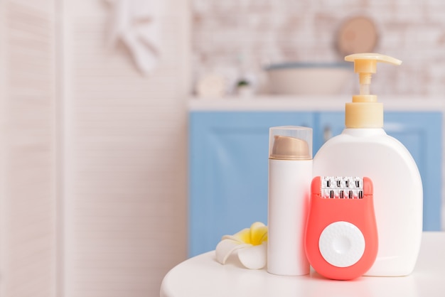 Épilateur moderne avec des produits cosmétiques sur la table dans la salle de bain