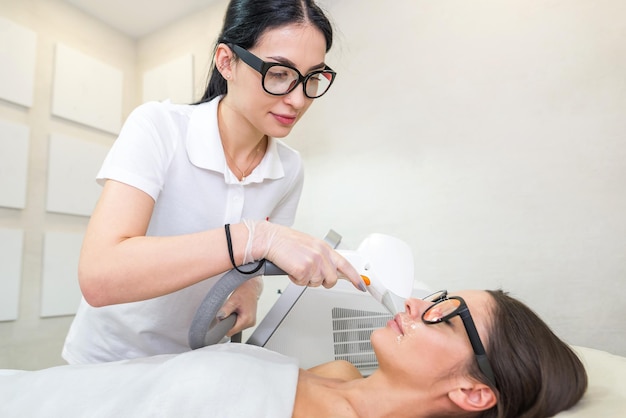 Épilation au laser Cheveux non désirés sur le visage jeune femme Concept de santé et de beauté jeune femme recevant un traitement d'épilation au laser sur le visage dans le salon