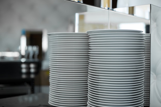 Pile d'assiettes blanches propres dans un restaurant. Événement préparer détails