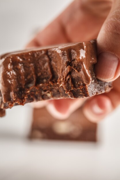 Pile de barres de fudge au chocolat sur fond blanc. Dessert végétalien cru.