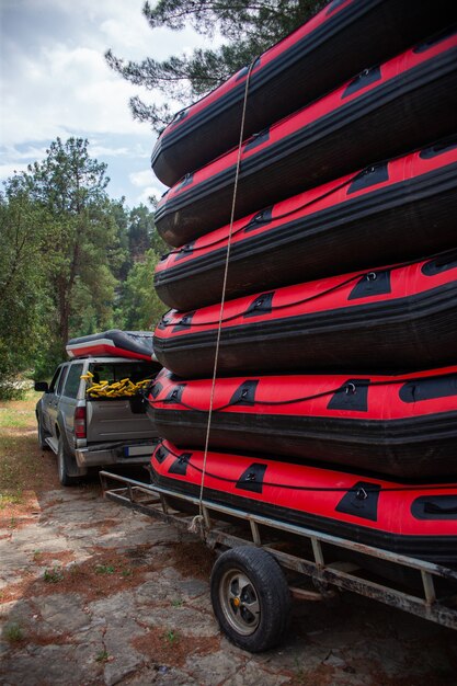 Pile de bateaux de rafting gonflables près de la voiture