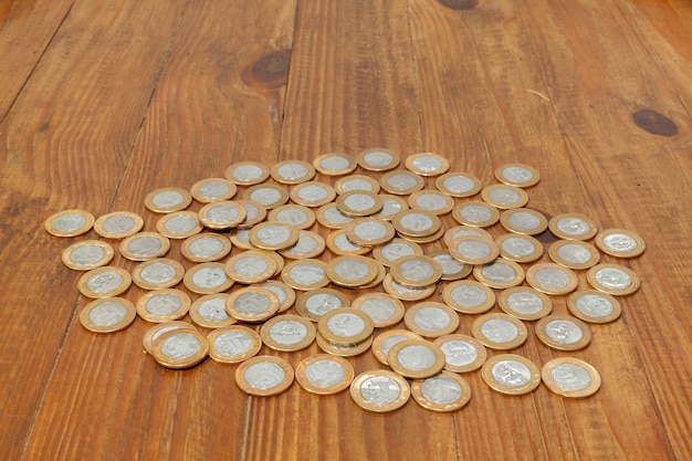 Une pile avec beaucoup de vraies pièces d'argent brésilien sur une table en bois