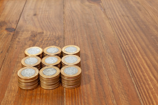 Une pile avec beaucoup de vraies pièces d'argent brésiliennes empilées sur une table en bois