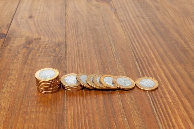 Photo une pile avec beaucoup de vraies pièces d'argent brésiliennes empilées sur une table en bois