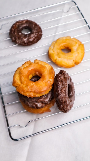 Une pile de beignets sur une grille, l'un étant glacé et l'autre glacé.