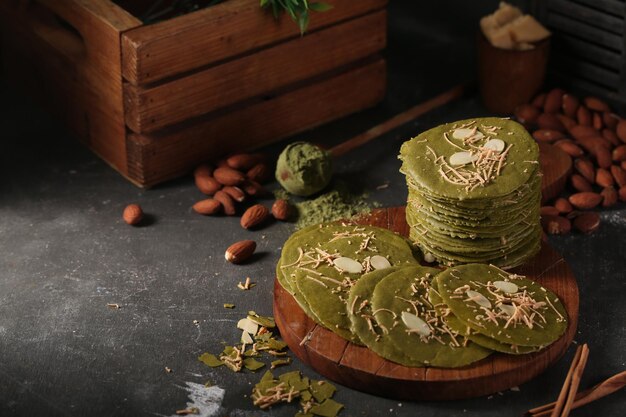 Photo une pile de biscuits au thé vert avec des noix sur une planche de bois.