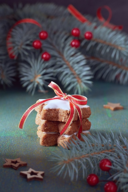 Pile de biscuits étoile de Noël ligoté ruban rouge moelle sur vert et rouge de fête