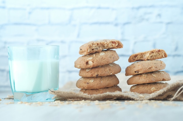 Pile de biscuits de repas entiers et verre de lait sur fond de bois