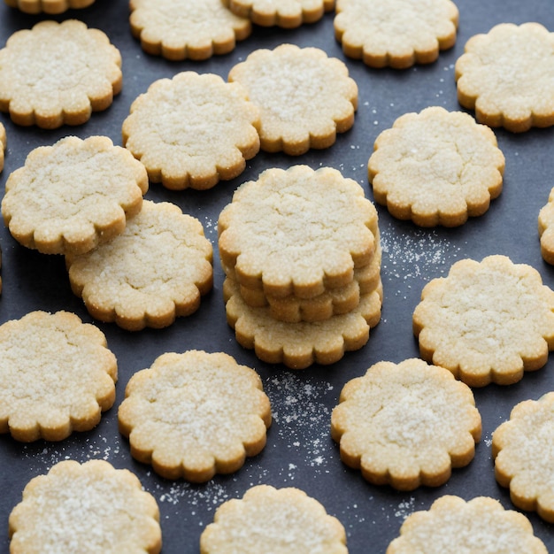 Une pile de biscuits sablés avec une pincée de sucre sur le dessus.