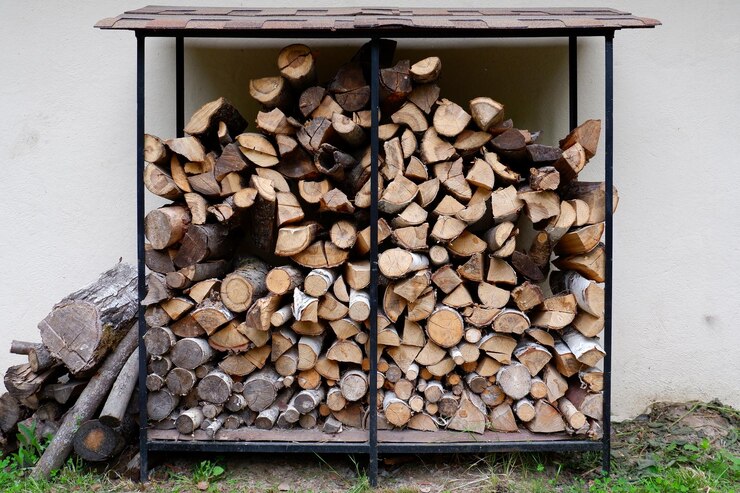 Photo une pile de bois de chauffage dans la cour contre un mur blanc