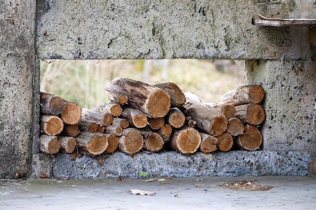 pile de bois de chauffage entre des murs de béton