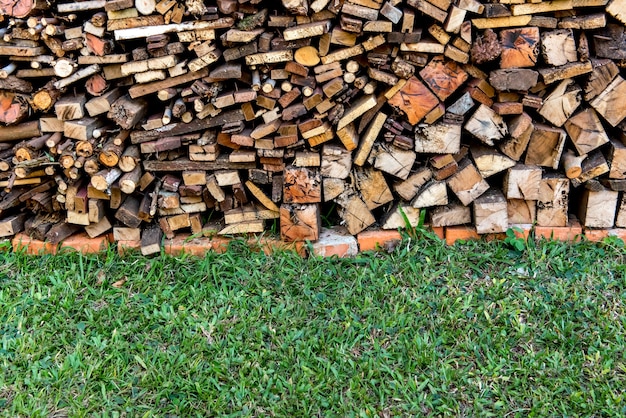 Pile de bois de chauffage et fond d'herbe.