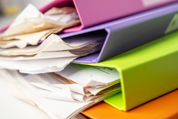 Photo une pile de classeurs multicolores sur la table du bureau.